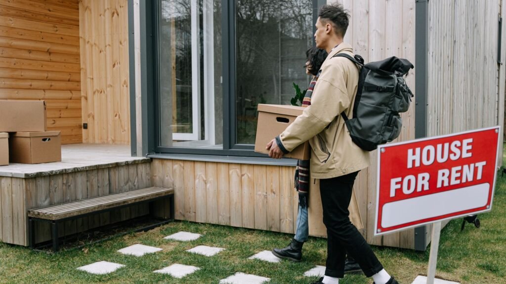 Pareja entrando en una vivienda de alquiler con cajas de mudanza