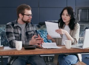 Pareja joven revisando ayudas y documentación económica en España en 2026