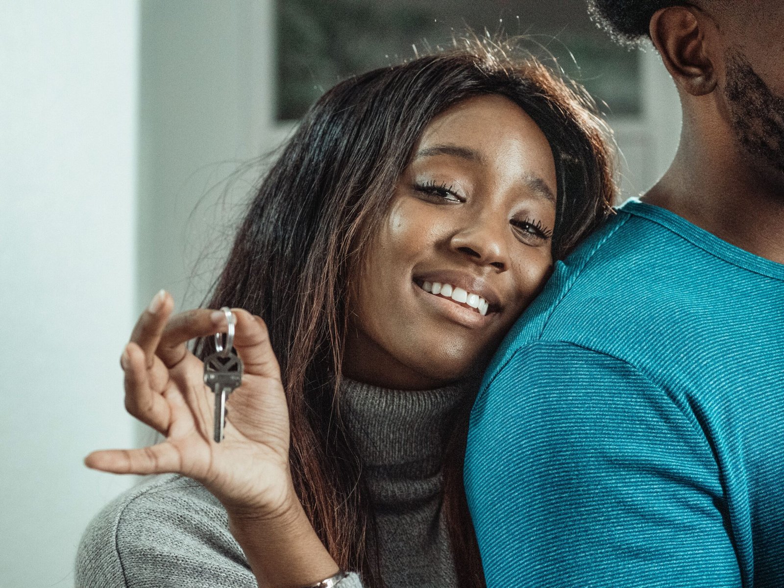 Pareja joven celebrando la compra de su primera vivienda