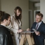 Pareja firmando la compra de una vivienda con un agente inmobiliario