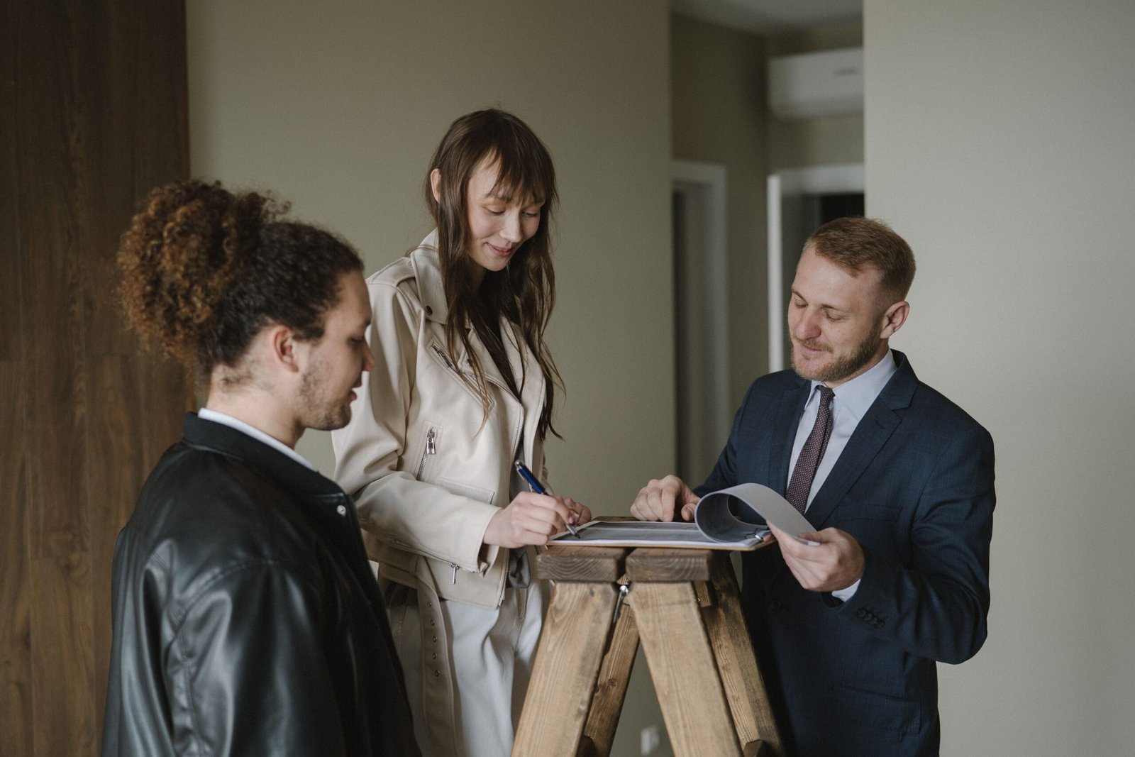 Pareja firmando la compra de una vivienda con un agente inmobiliario