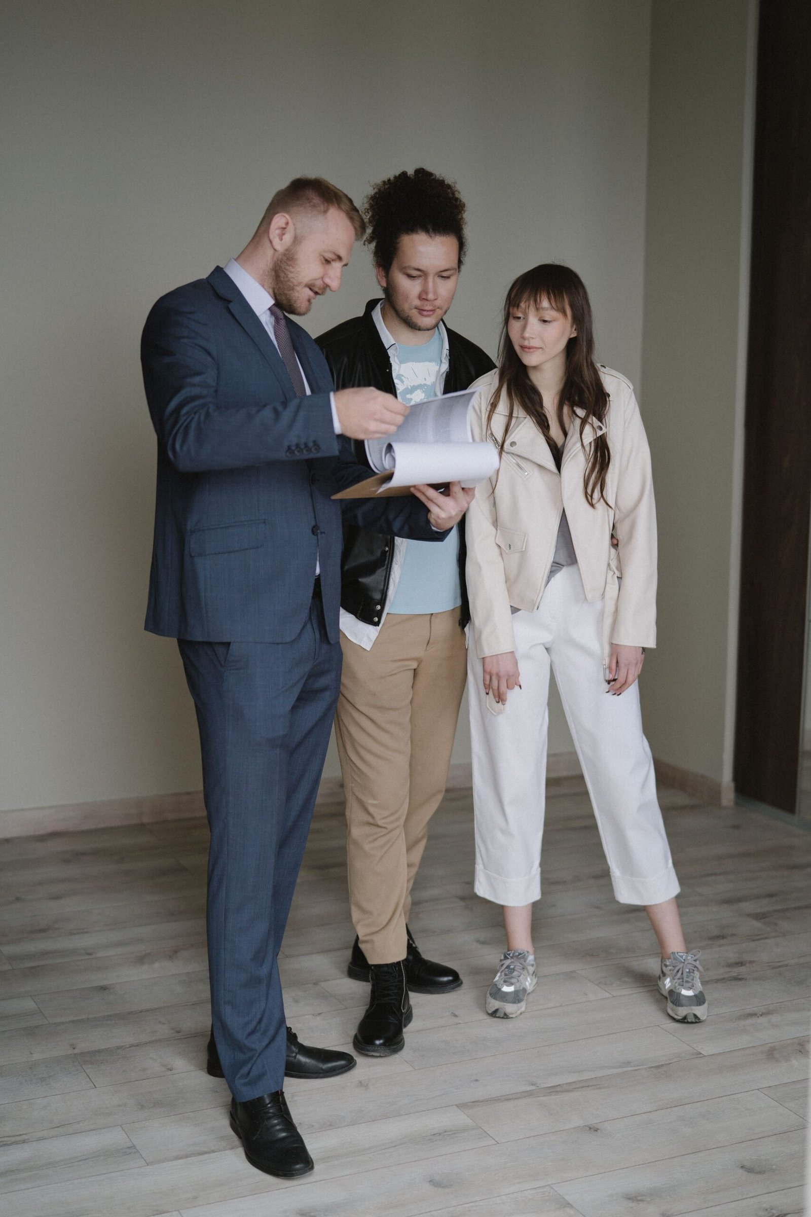 Pareja revisando con un profesional las condiciones de un contrato de vivienda
