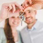 Pareja joven mostrando las llaves de su primera vivienda en Cataluña