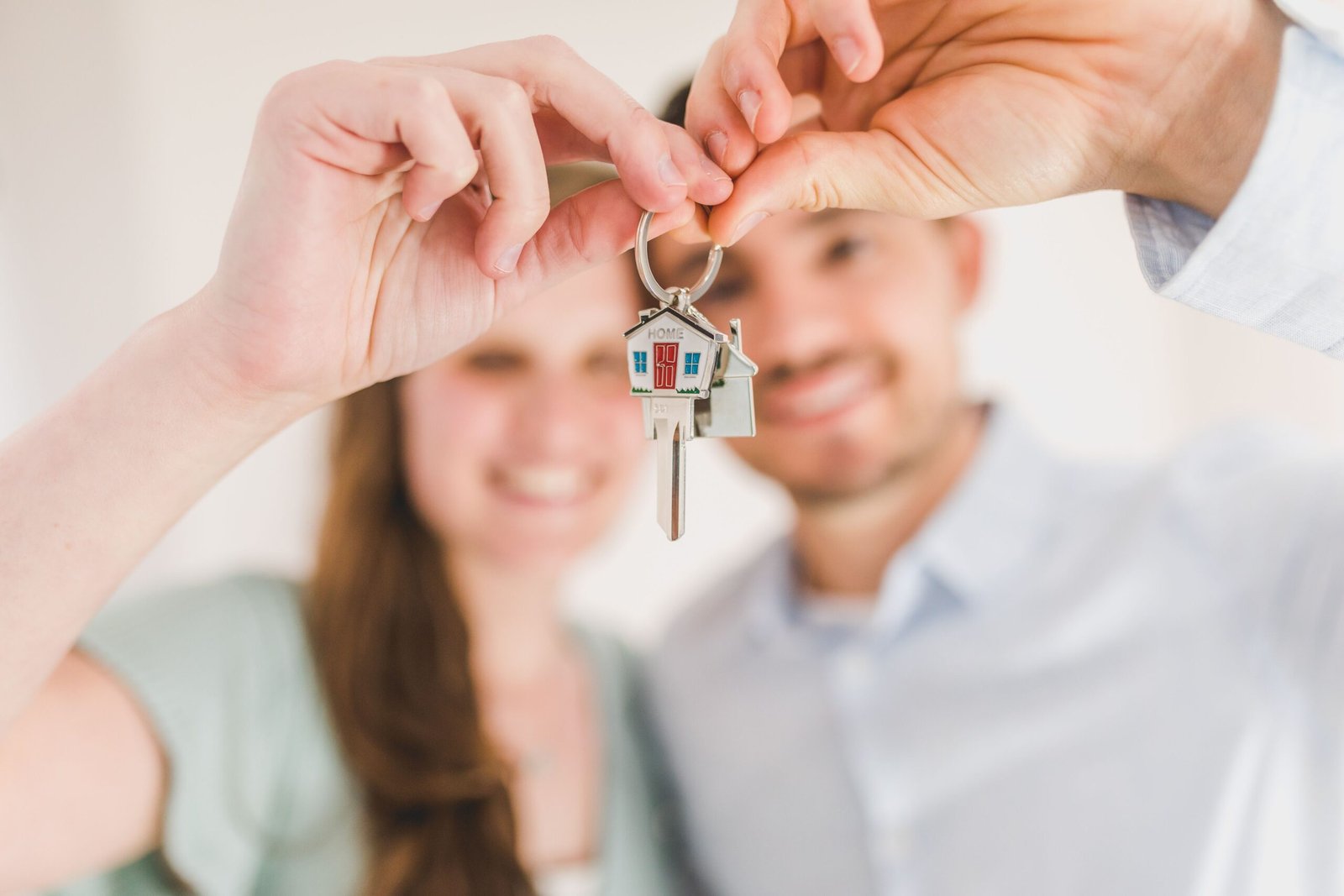 Pareja joven mostrando las llaves de su primera vivienda en Cataluña